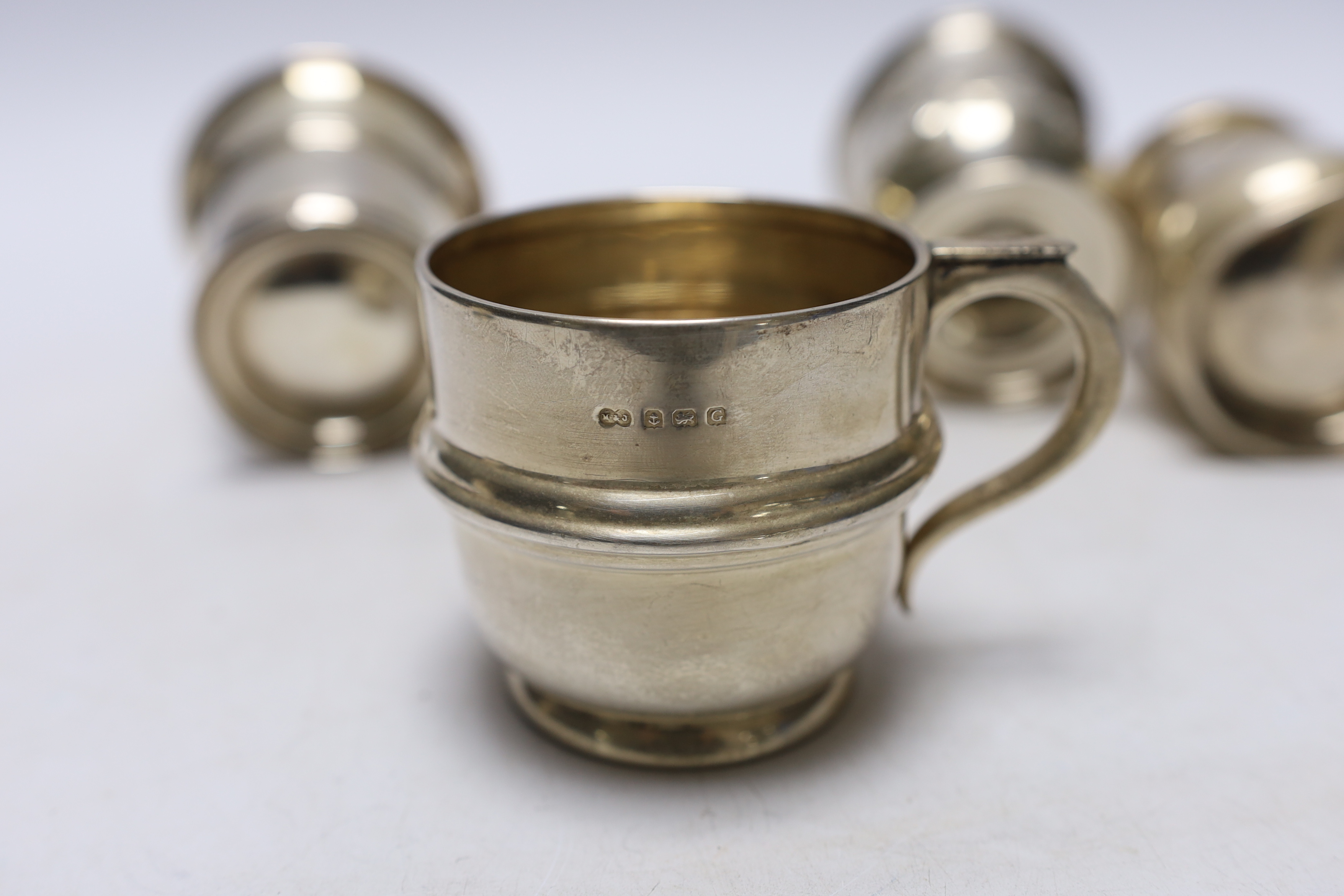 An early Victorian repousse silver pedestal christening mug, Charles Fox, London, 1839, 95mm and three later silver christening mugs, 10.7oz.